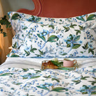 Pillow with Fantasia printed cotton duvet and breakfast tray with tea and croissant in cozy morning light
