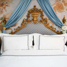 Front view of luxury hotel-style bed with Villa Cotton navy embroidered duvet cover and Oxford pillow shams