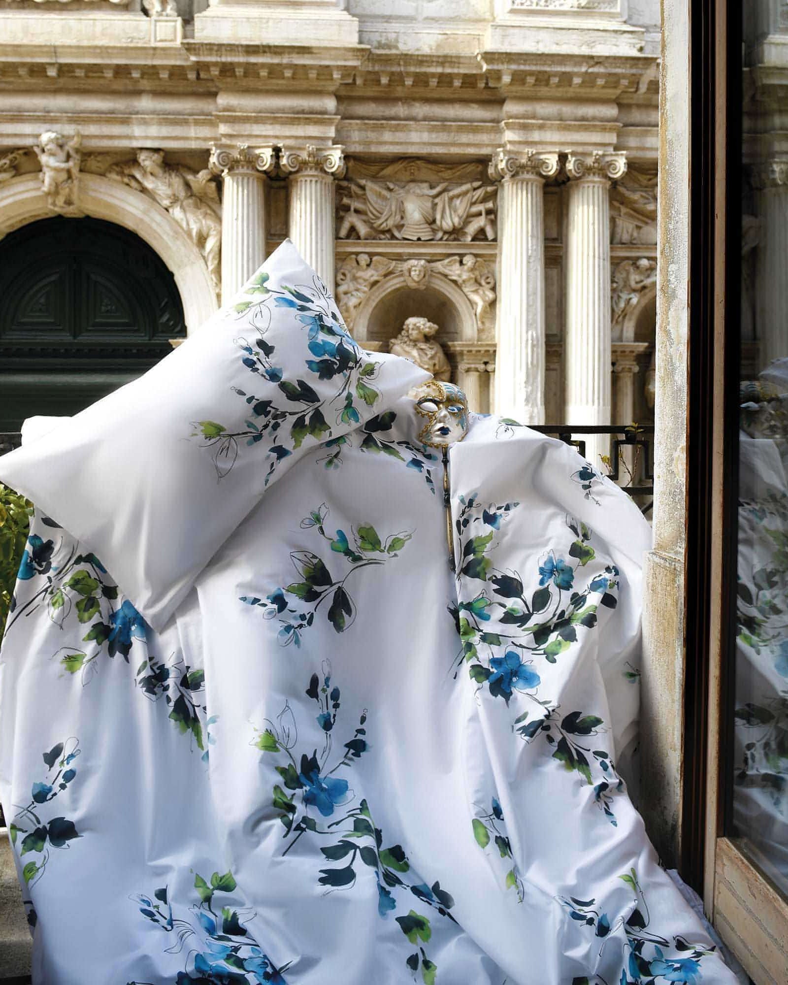 Primavera floral cotton duvet cover draped on balcony with classical European architecture in background