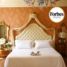 Luxurious white duvet cover set with silver embroidery in opulent bedroom setting, endorsed by Forbes