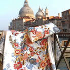 Villaggio printed bedding draped over railing with Venice skyline and domes in background