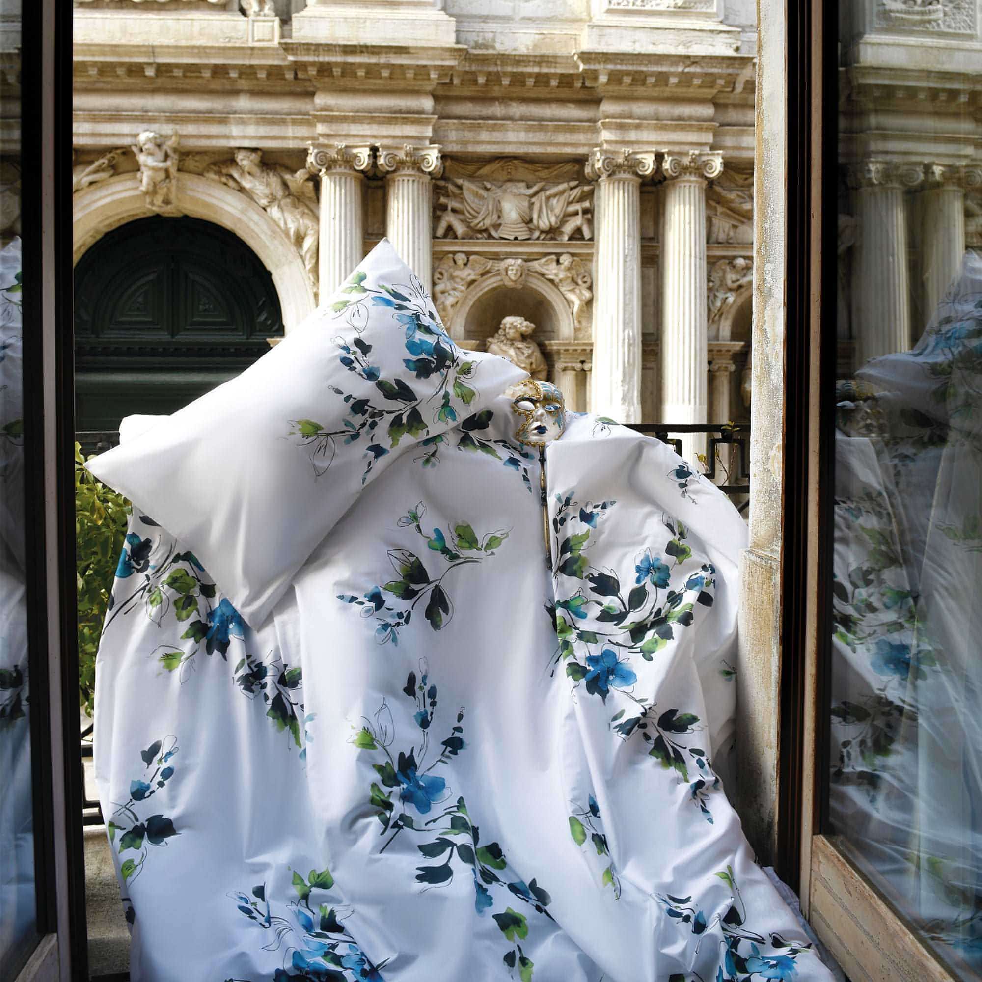 Primavera floral cotton duvet cover draped on balcony with classical European architecture in background